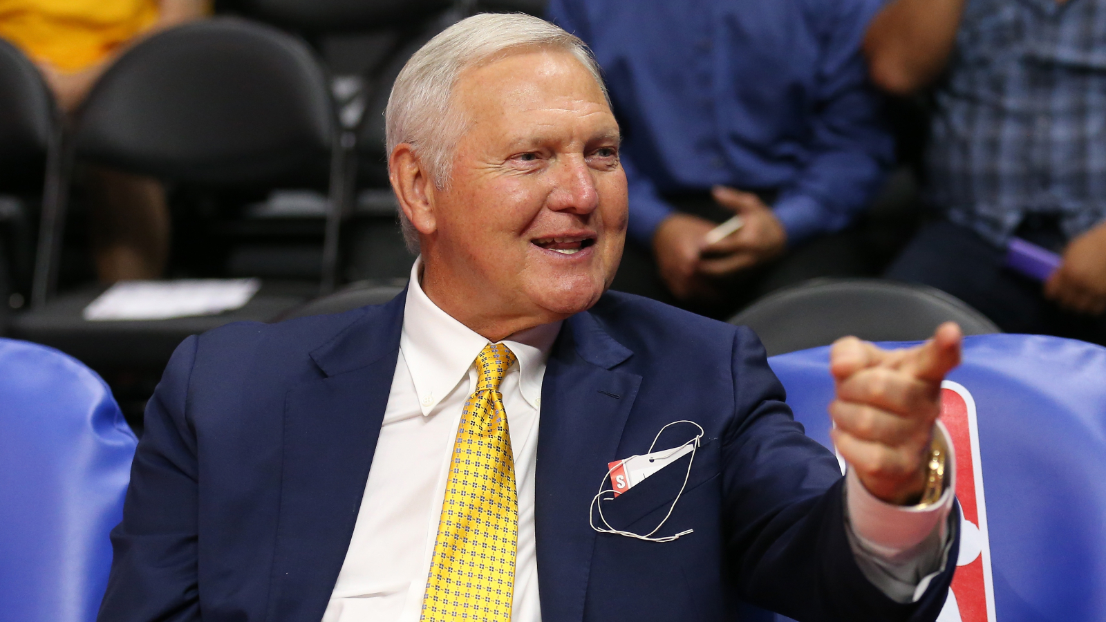 Jerry West sits courtside during an NBA game.