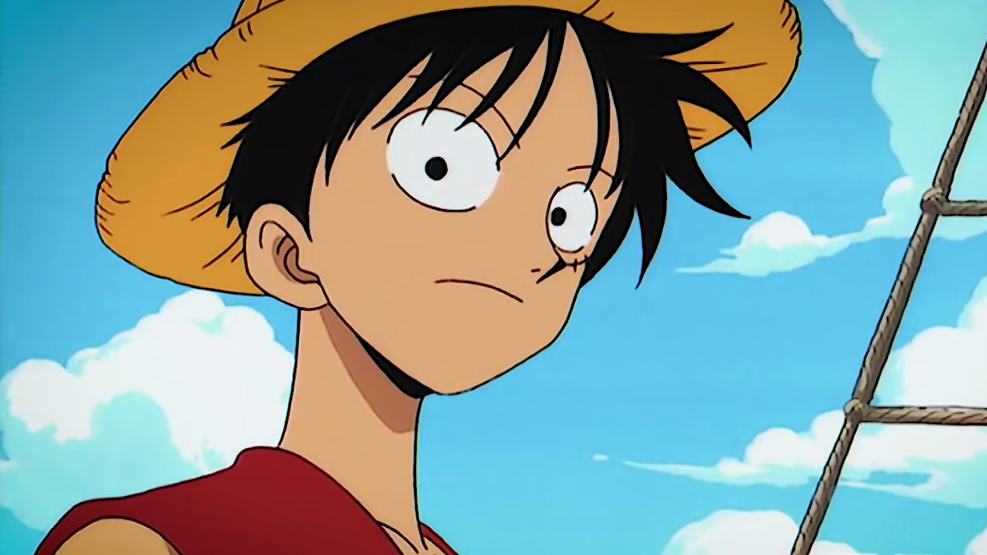 Luffy is wearing a hat and looking at something out of the corner of his eye.