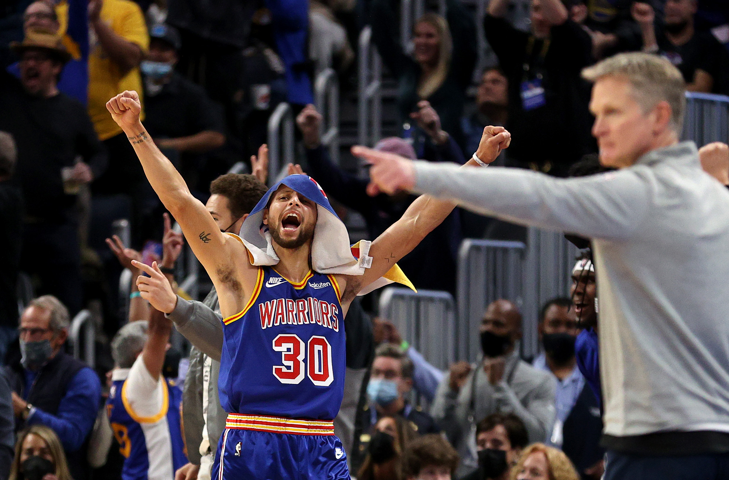 Steph Curry celebrates while Steve Kerr coaches