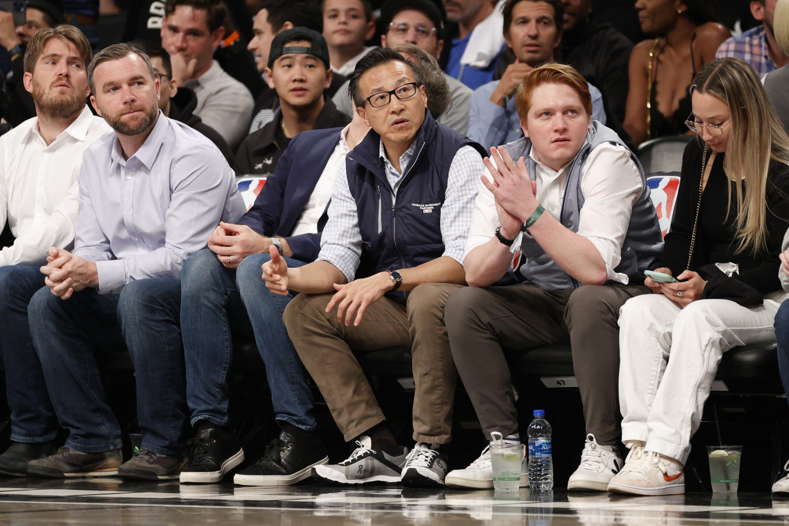 Joe Tsai, seated courtside at a home game for his Brooklyn Nets