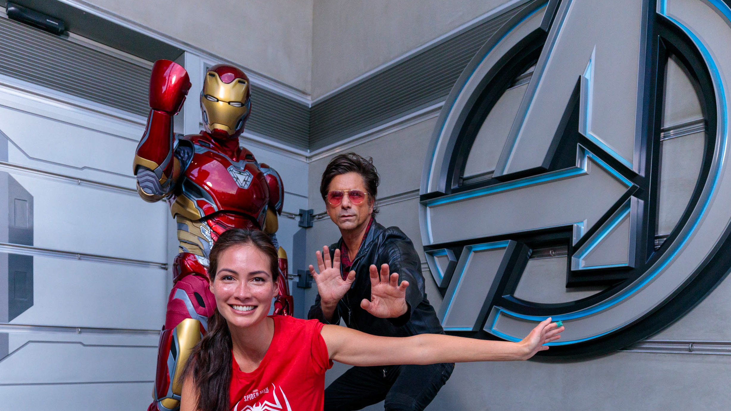 In this handout photo provided by Disney Resorts, John Stamos and Caitlin McHugh pose with Iron Man at Disney California Adventure Park on August 01, 2022 in Anaheim, California. The second season of "Spidey and his Amazing Friends" premieres on Disney Channel and Disney Junior on August 19, 2022.