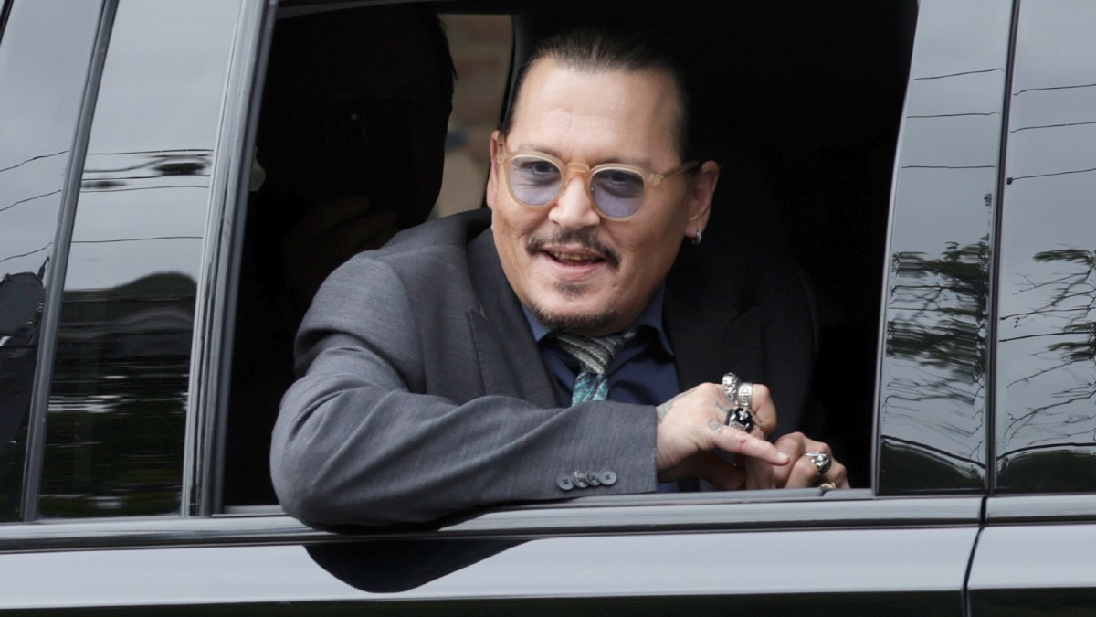 Actor Johnny Depp watches as supporters wave as he leaves the Fairfax County Courthouse on May 25, 2022 in Fairfax, Virginia.