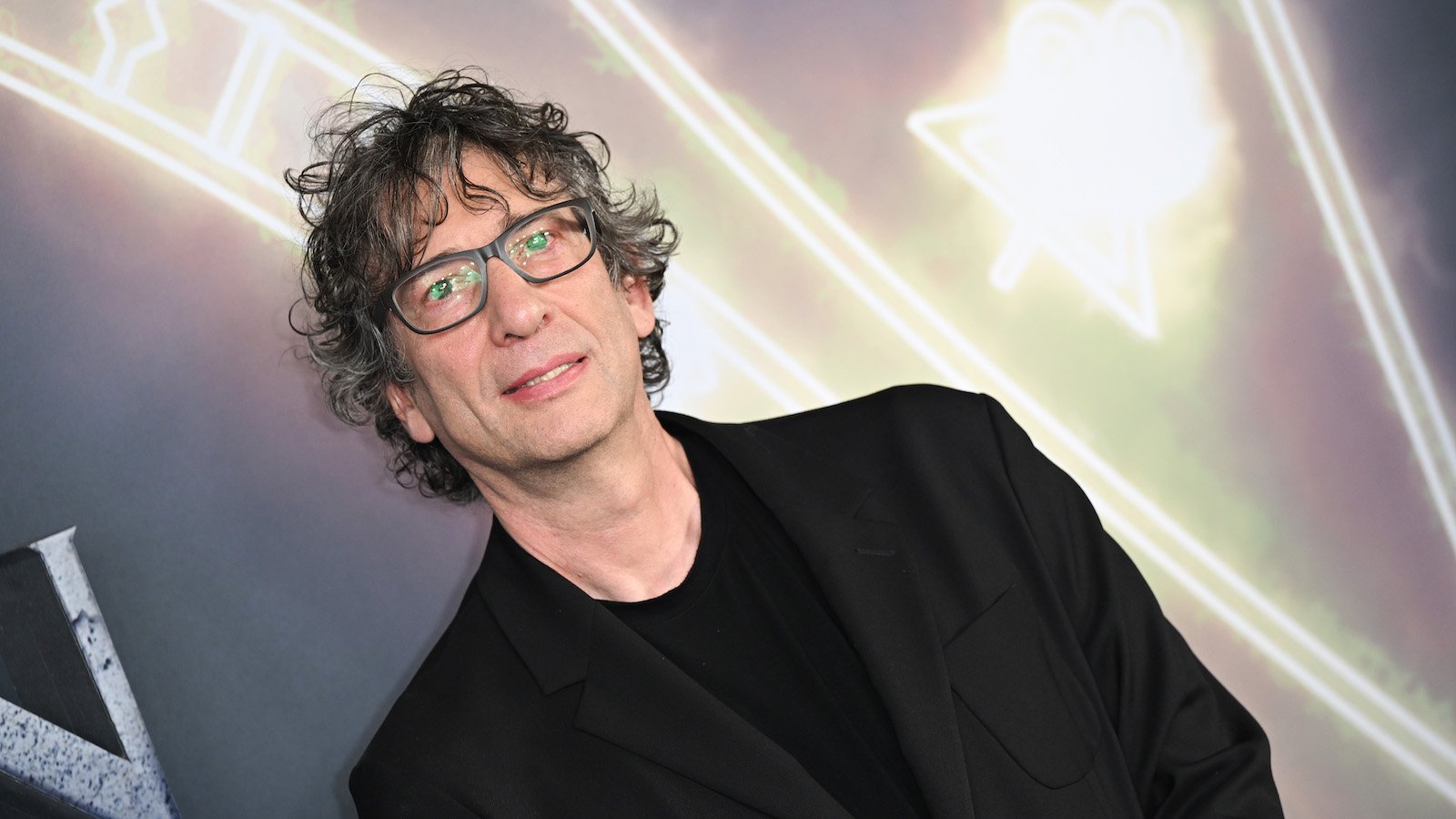 Neil Gaiman attends the London The Sandman premiere in a black suit