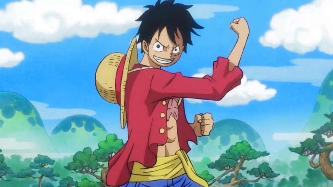 Luffy smiles at the camera and holds his fist up in the air. 