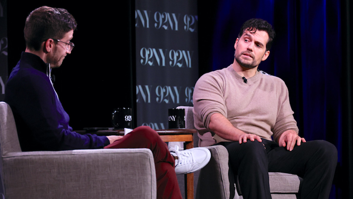 Henry Cavill sitting in a chair across for interviewer, Josh Horowitz