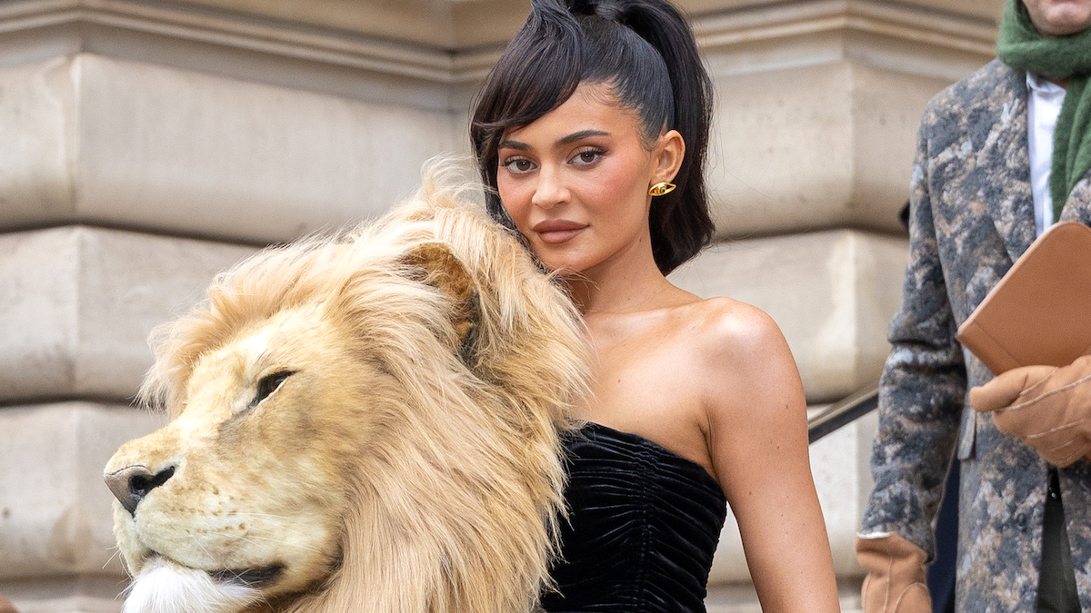 Kylie Jenner wearing a strapless black dress and an oversized lions head as a broach