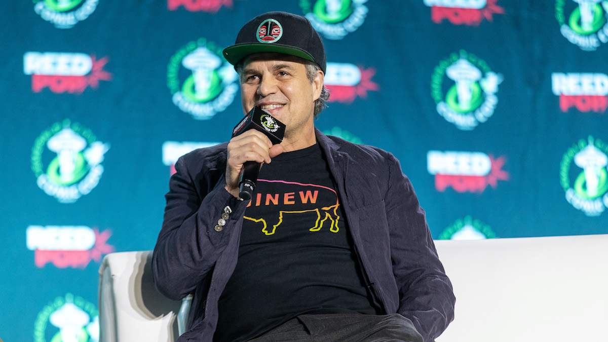 Mark Ruffalo speaking on stake with a microphone in his hand