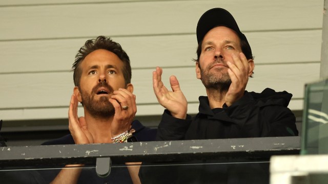 WREXHAM, WALES - APRIL 22: Wrexham co-owner Ryan Reynolds chats with actor Paul Rudd during the Vanarama National League match between Wrexham and Boreham Wood at Racecourse Ground on April 22, 2023 in Wrexham, Wales.