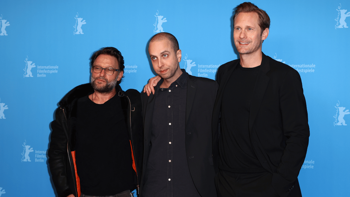 The Skarsgård siblings are standing together on a red carpet. 