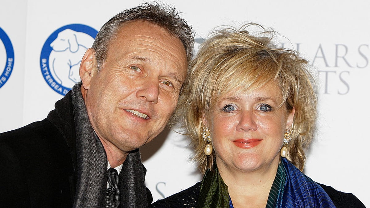 Sarah Fisher and Anthony Head are taking a picture on a red carpet.