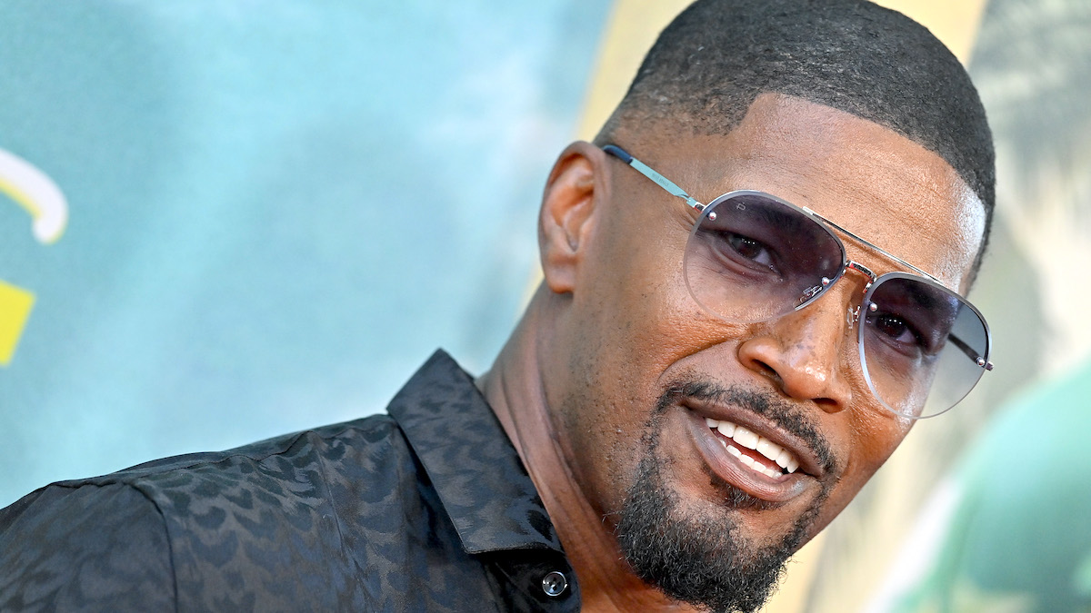 Jamie Foxx wearing sunglasses and a black collared shirt while he attends the World Premiere of Netflix's "Day Shift"