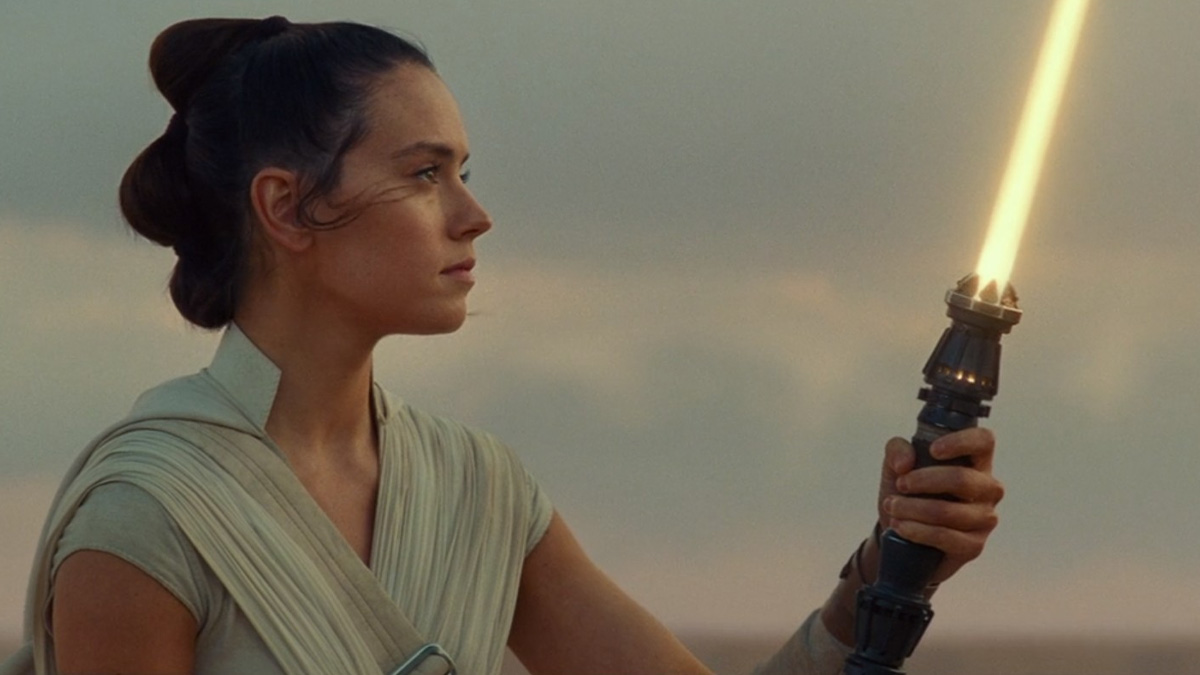 Rey looks at her orange lightsaber