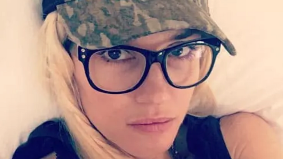 Gwen Stefani is taking a selfie with glasses and a hat.