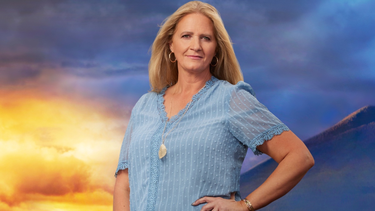 Christine Brown standing in front of a sunset, in a blue top.