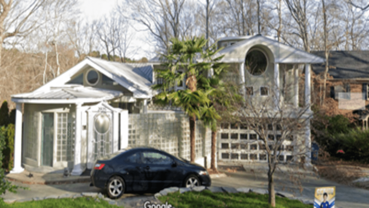 The exterior of an odd home largely consisting of bubble glass and pillars. 