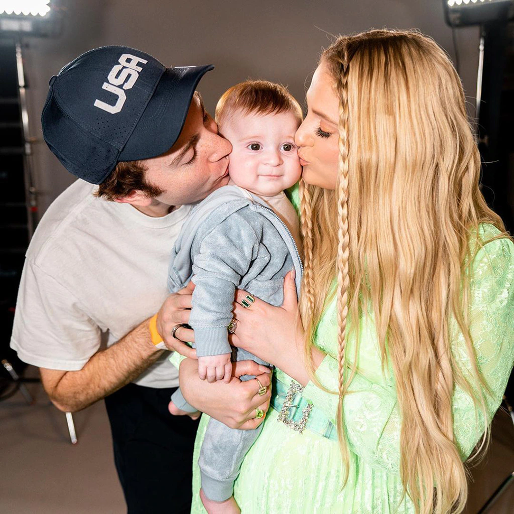 Daryl Sabara and Meghan Trainor holding one of their children.