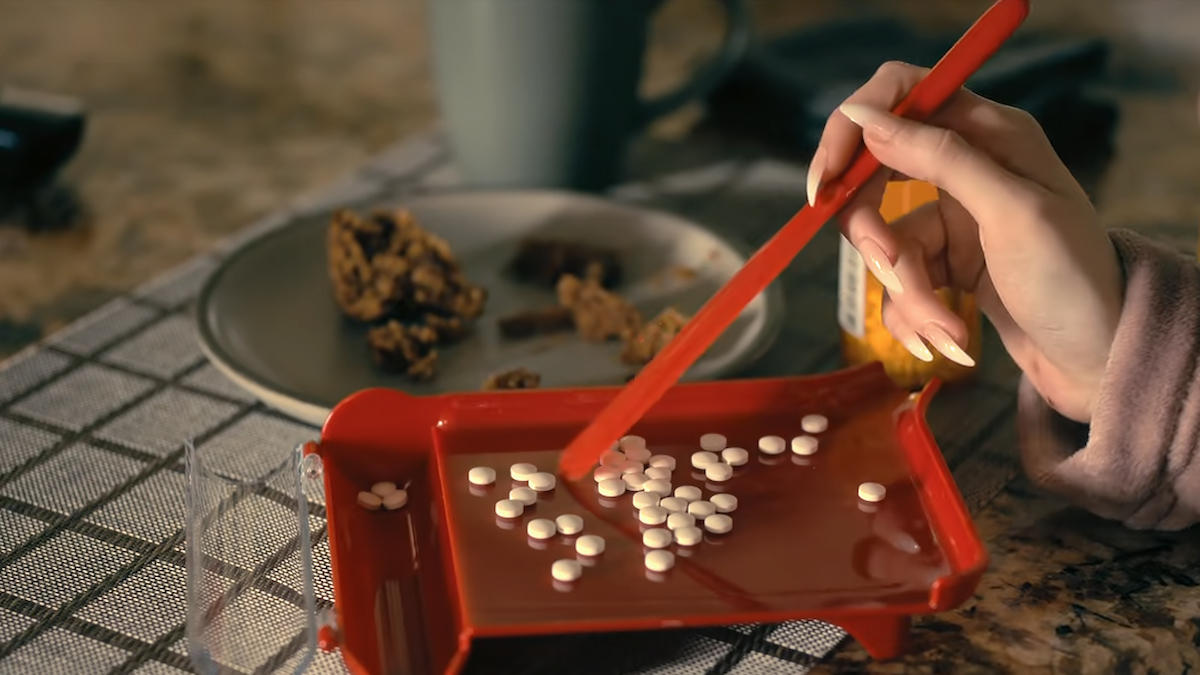 A character is counting and sorting Ligadone pills.