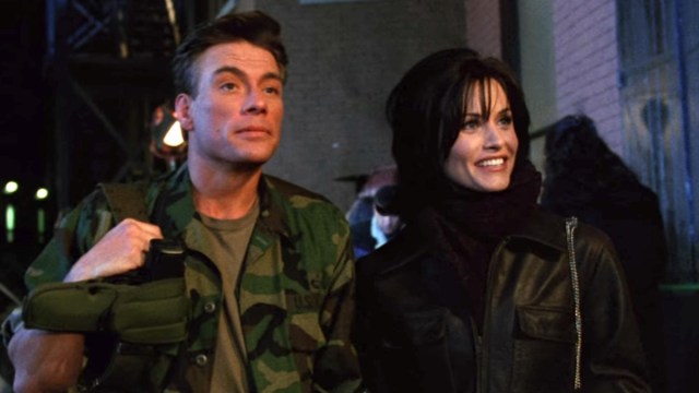 A man in camo stands next to a woman with dark brown hair