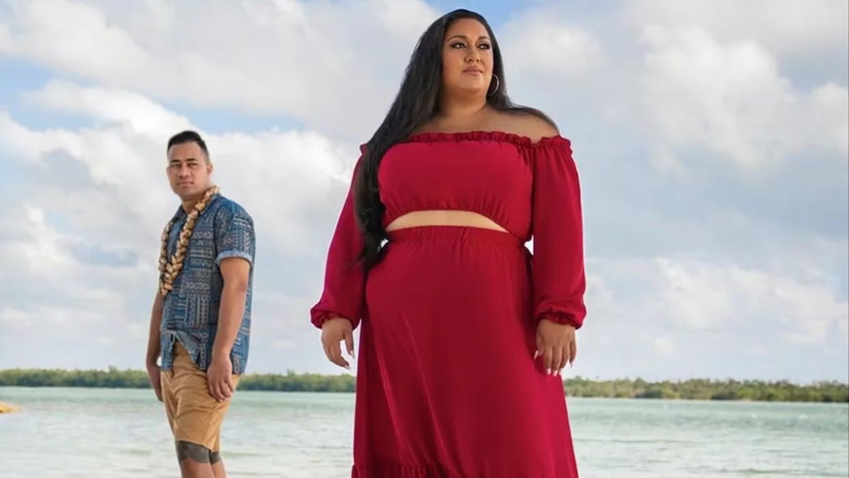 Kalani and Aseulu look opposite ways on the beach.