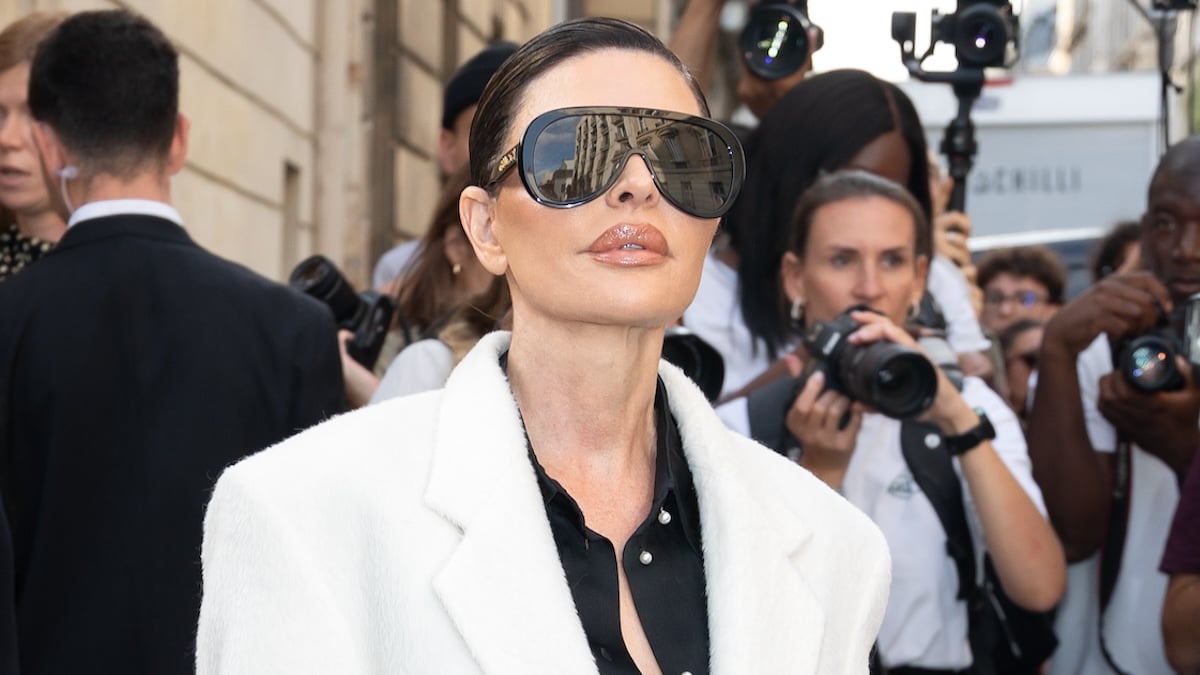 Lisa Rinna waring a white fur coat, oversized sunglasses, and slicked-back hair at the Victoria Beckham Womenswear Spring/Summer 2024 show