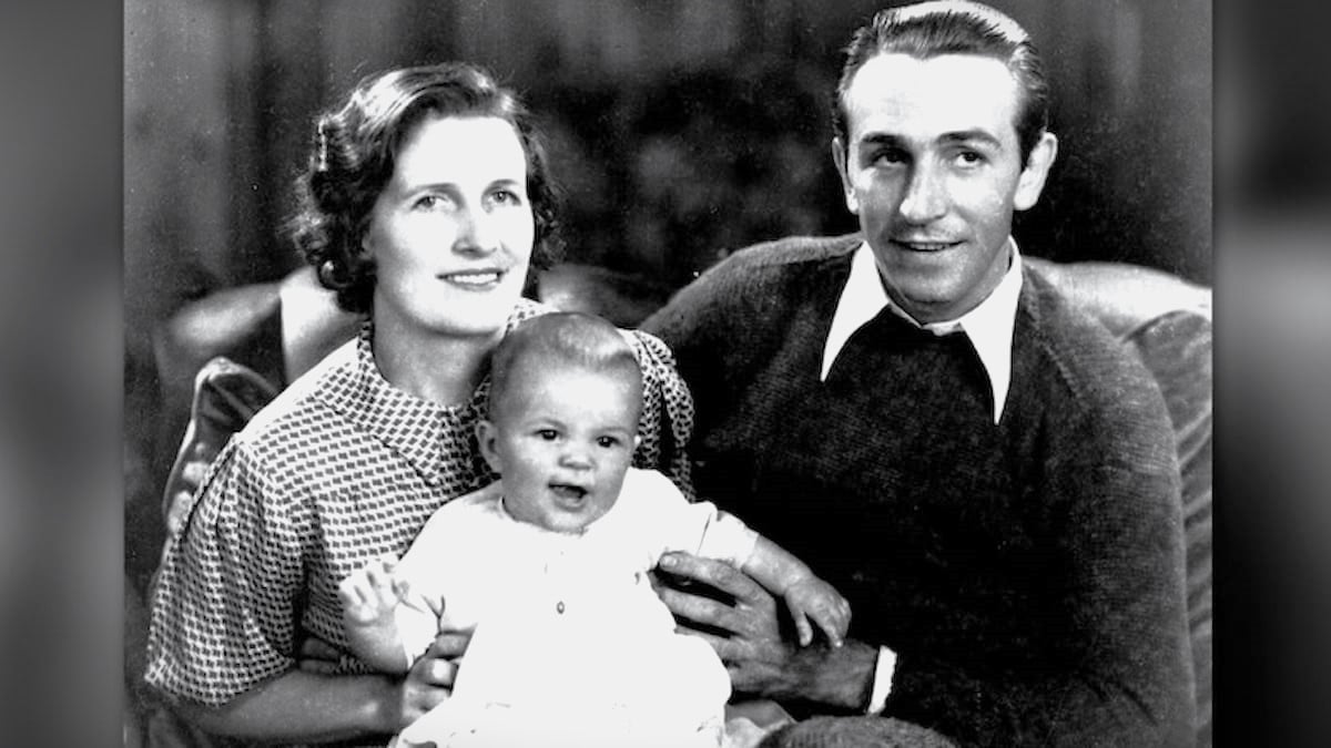 Walter Disney poses for a photo with his wife and infant daughter. 