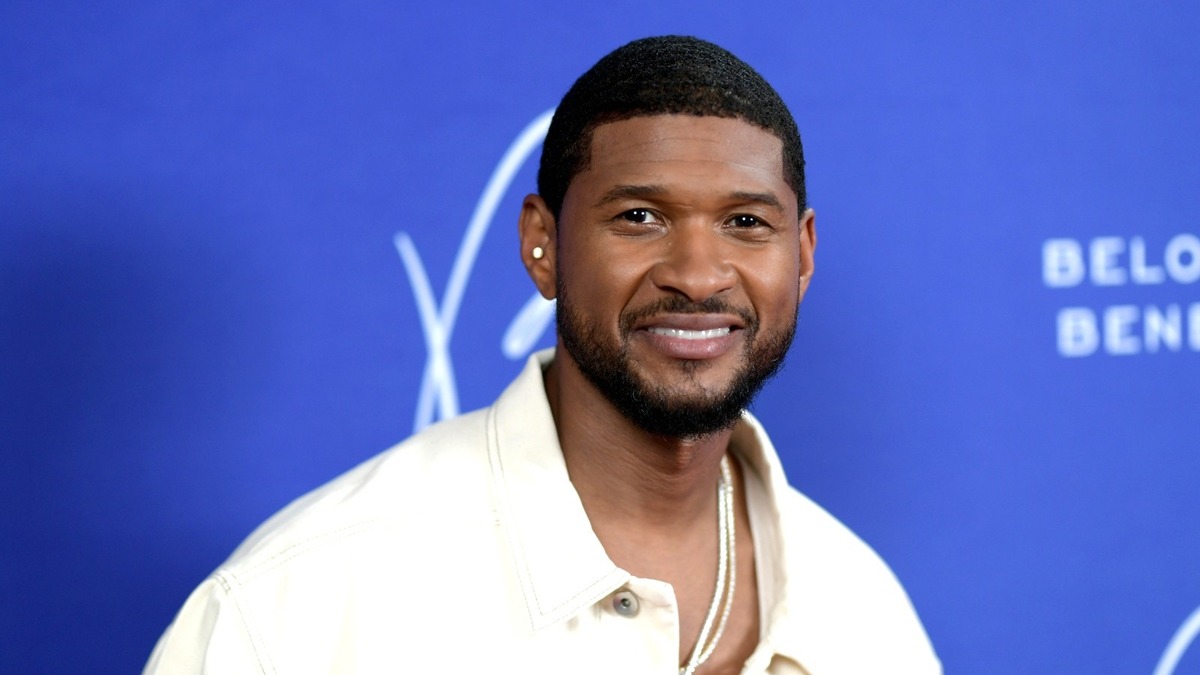 Usher smiling as he attends the 2022 Beloved Benefit at Mercedes-Benz Stadium.