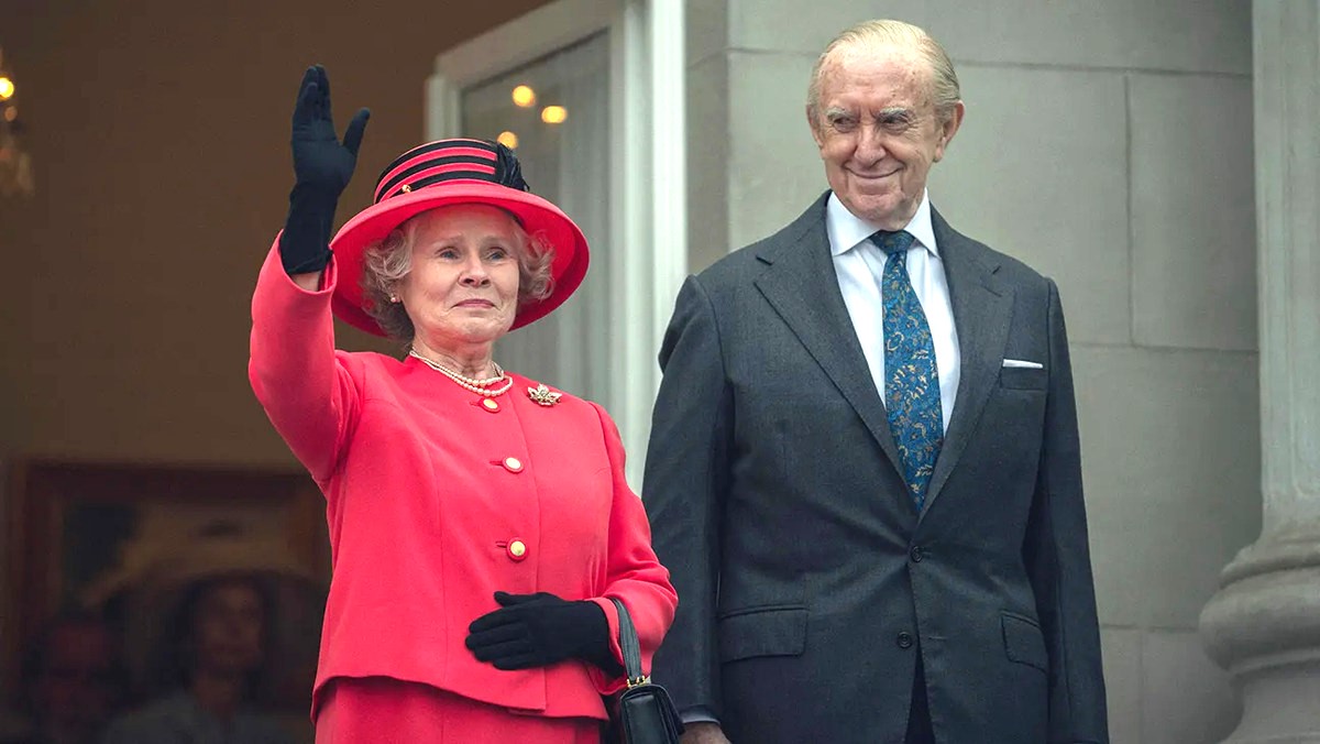 Queen Elizabeth II (Imelda Staunton) and Prince Philip (Jonathan Pryce) greet  an unseen crowd from the balcony of Buckingham Palace in The Crown season 6 part 2