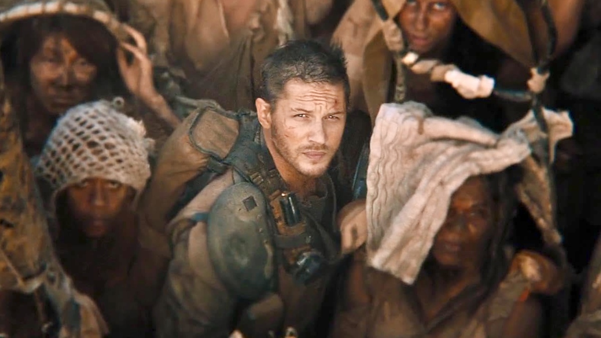 A still of Tom Hardy glancing upwards surrounded by extras in the ‘Max Max: Fury Road’ film