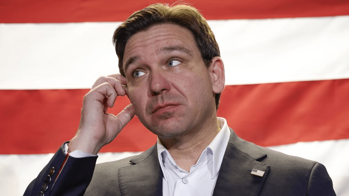 Republican presidential candidate Florida Governor Ron DeSantis smiles as he listens as Iowa Governor Kim Reynolds speaks at a "Countdown to Caucus" event at the Never Back Down Headquarters on January 13, 2024 in West Des Moines, Iowa. Iowa voters are preparing for the Republican Party of Iowa's presidential caucuses on January 15th.