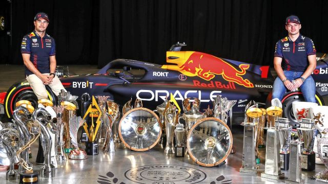 MILTON KEYNES, ENGLAND - DECEMBER 13: Sergio Perez of Mexico and Oracle Red Bull Racing (L) and Max Verstappen of the Netherlands and Oracle Red Bull Racing pose for a photo with trophies during Max & Checo's Homecoming at Red Bull Racing Factory on December 13, 2023 in Milton Keynes, England.