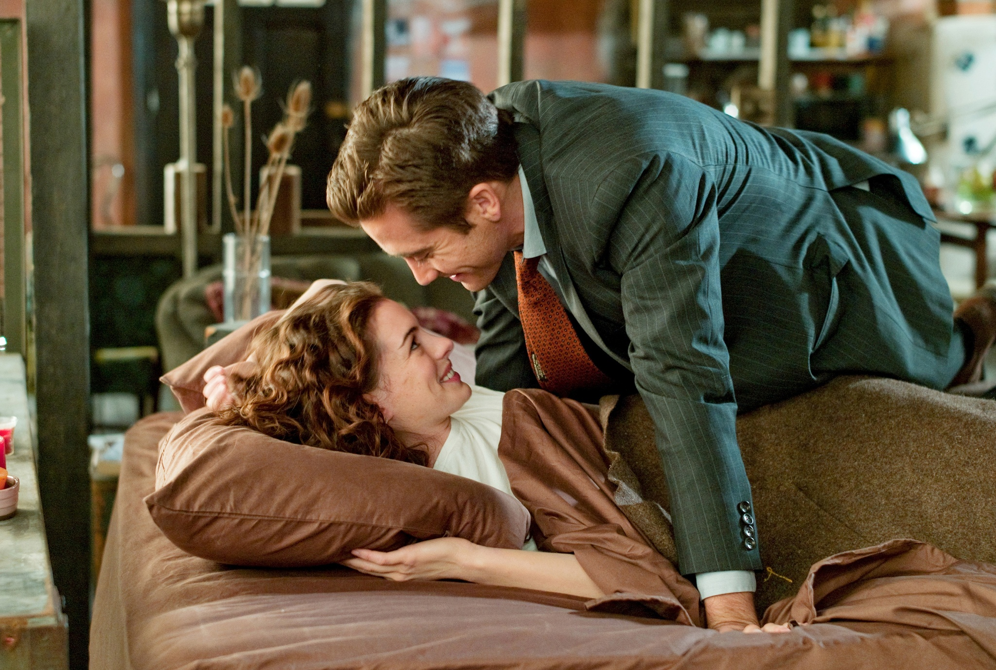 Anne Hathaway and Jake Gyllenhaal are looking at each other in Love and Other Drugs.