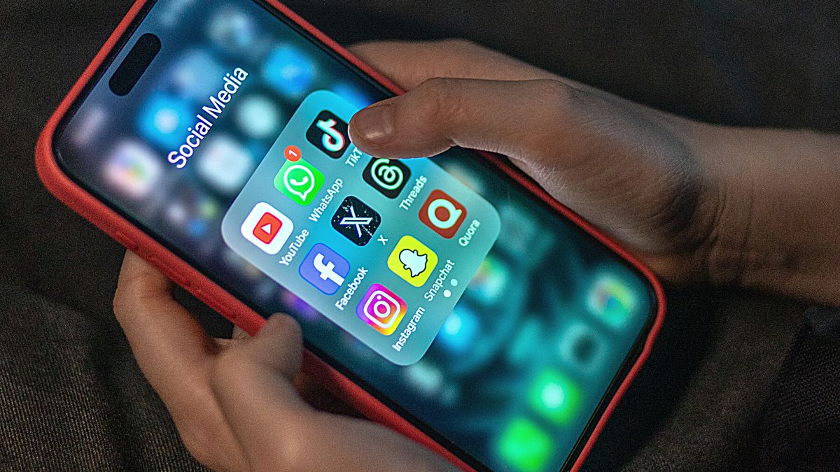 A 12-year-old boy looks at an iPhone screen showing various social media apps including TikTok, Facebook and X, on December 19, 2023 in Bath, England.