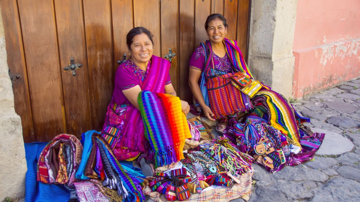 Close up to Senior mayan women in typical costume, selling handmade textiles and souvenirs at streets of Antigua, Guatemala