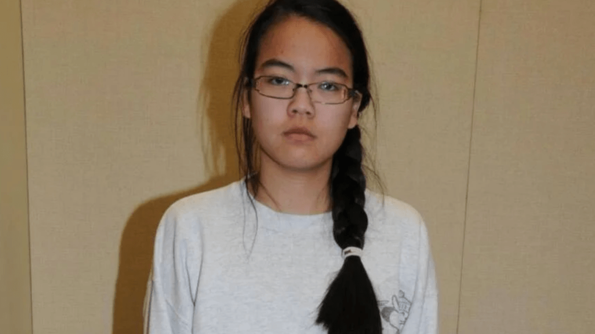 Jennifer Pan in a white shirt and glasses against a beige backdrop