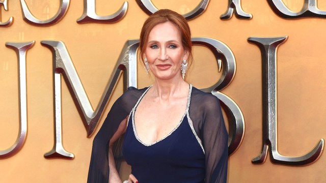 J.K. Rowling smiling in a navy dress and cape at the world premiere of 'Fantastic Beasts: The Secrets of Dumbledore'