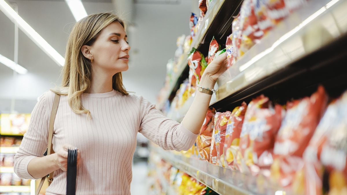 Woman Looking at Product at Grocery Store. Costumer Buying Food at the Market.