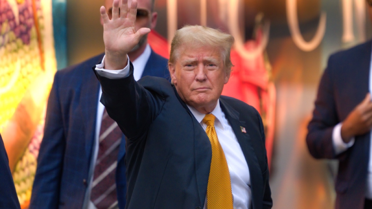 Donald Trump waves to supporters during trial