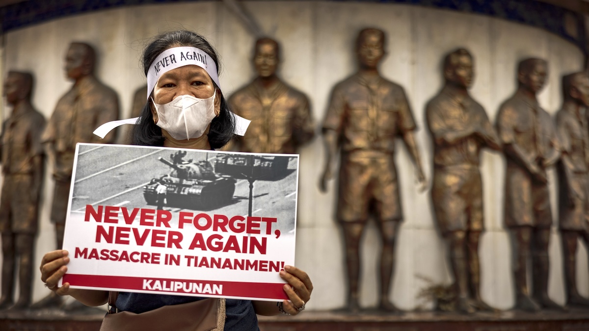 A Filipino woman holds up a sign protesting the anniversary of the Tiananmen Square Massacre