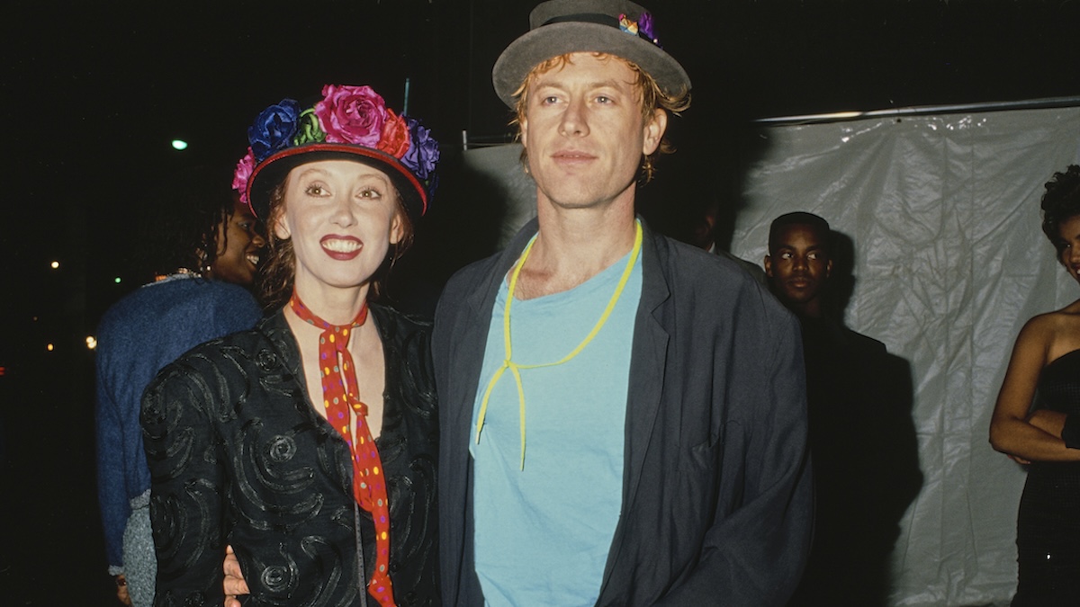 American actress Shelley Duvall, wearing a black jacket with a red neckerchief with multi-coloured polka dots and a floral trimmed hat, and American singer, songwriter and musician Dan Gilroy, who wears a black jacket over a turquoise blue t-shirt with a grey hat.