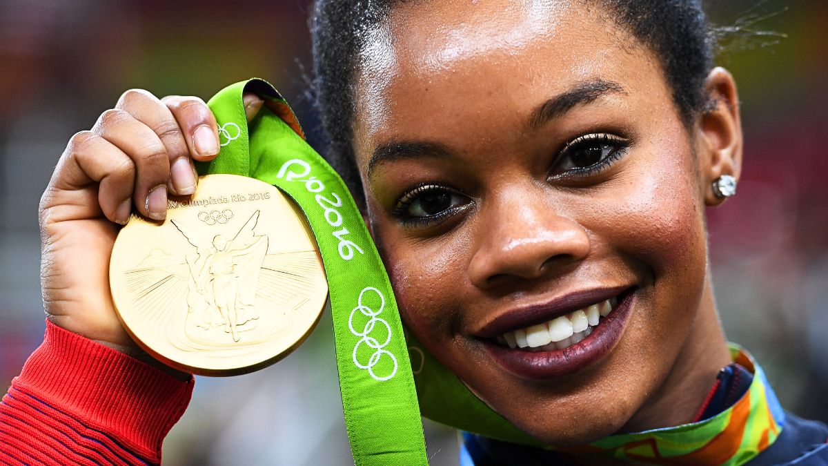 Gabrielle Douglas of the United States poses for photographs with her gold medal after the medal ceremony for the Artistic Gymnastics Women's Team on Day 4 of the Rio 2016 Olympic Games at the Rio Olympic Arena on August 9, 2016 in Rio de Janeiro, Brazil.