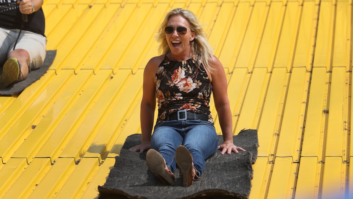 U.S. Rep. Marjorie Taylor Greene (R-GA) rides the giant slide during a visit to the Iowa State Fair