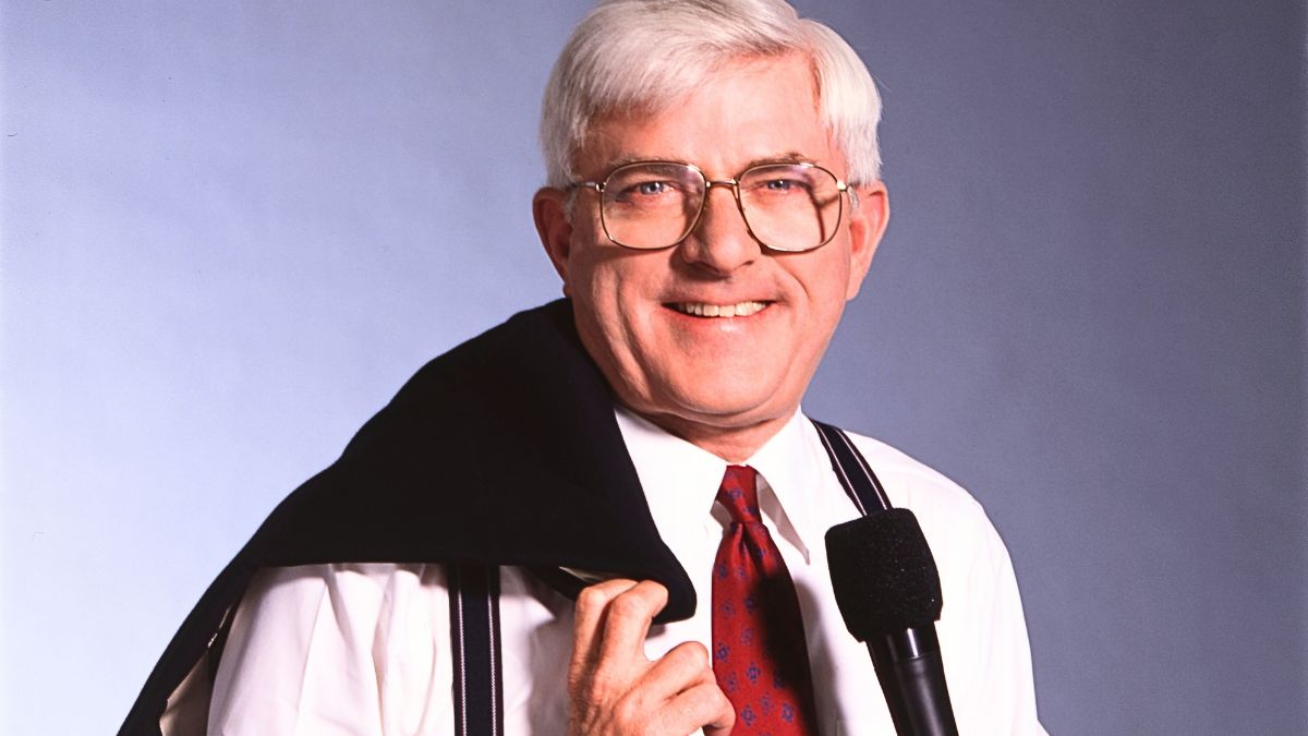 Portrait of American television personality Phil Donahue as he poses with his jacket over his shoulder and a microphone in one hand, New York, New York, May 19, 1992. This photo was taken as part of a shoot for TV Guide magazine.