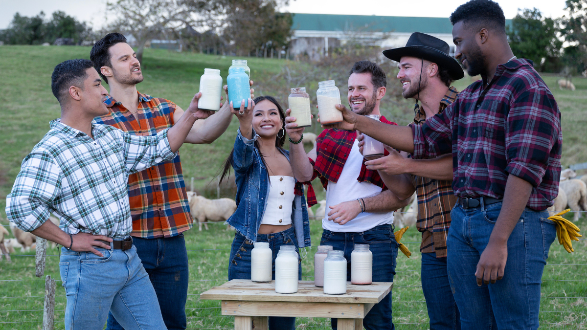 'The Bachelorette' season 21 contestants standing around a table and cheering with drinks