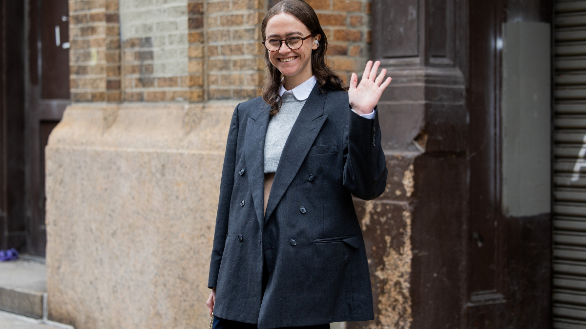 Ella Emhoff in grey coat waving